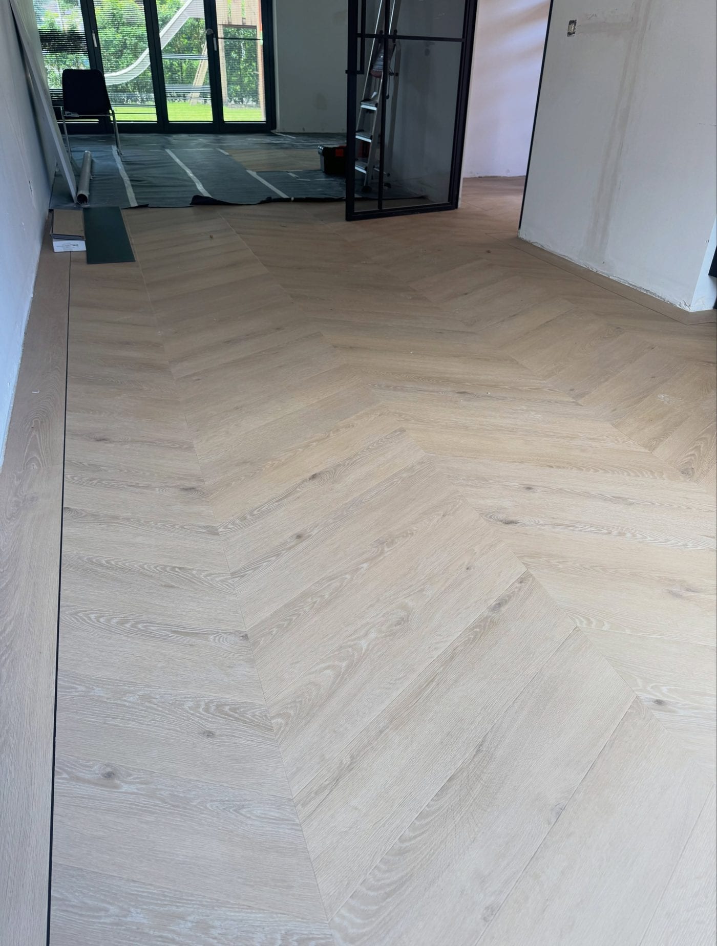 Hongaarse punt in licht eiken PVC, doorlopend door de hele woonkamer