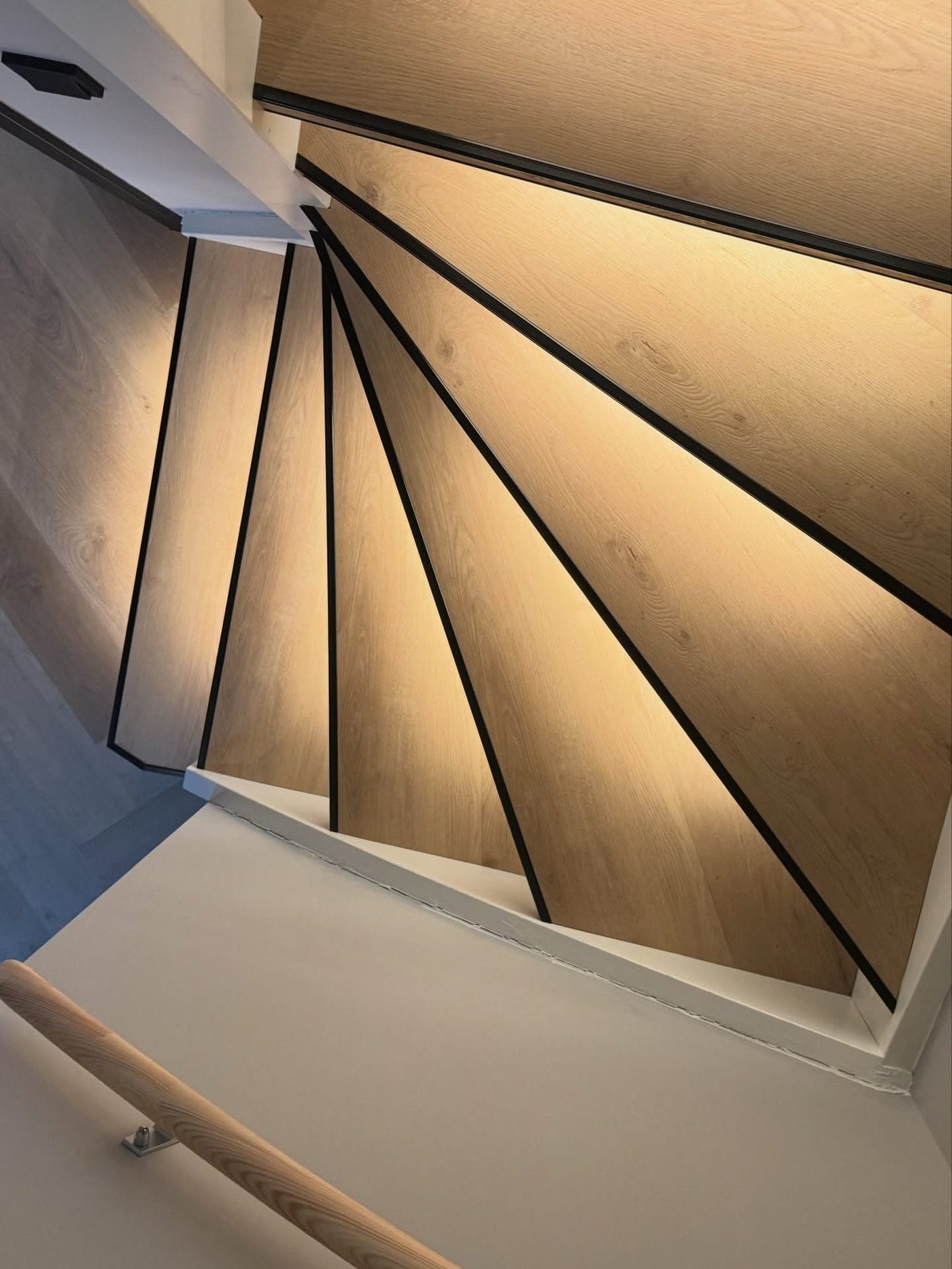Onderaanzicht van een trap met verlichting weggewerkt in de neus van de treden
