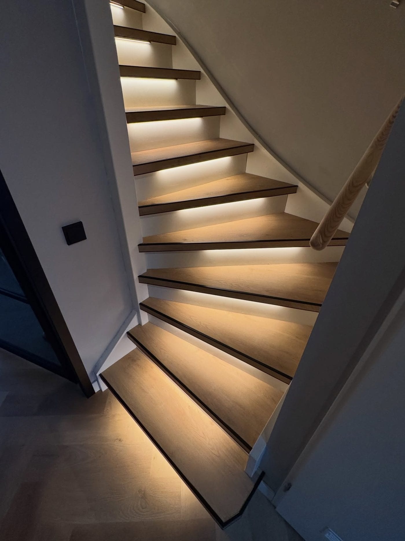 Trap met PVC-overzettreden en LED-strips die de treden van onderaf verlichten