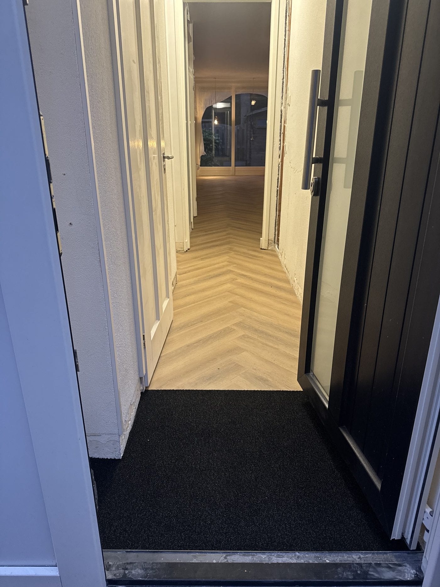 Visgraat vanaf de voordeur gezien, met een schoonloopmat in de entree